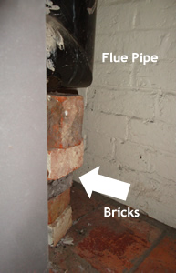 Dangerously installed Stove installed using bricks to support the flue!!!